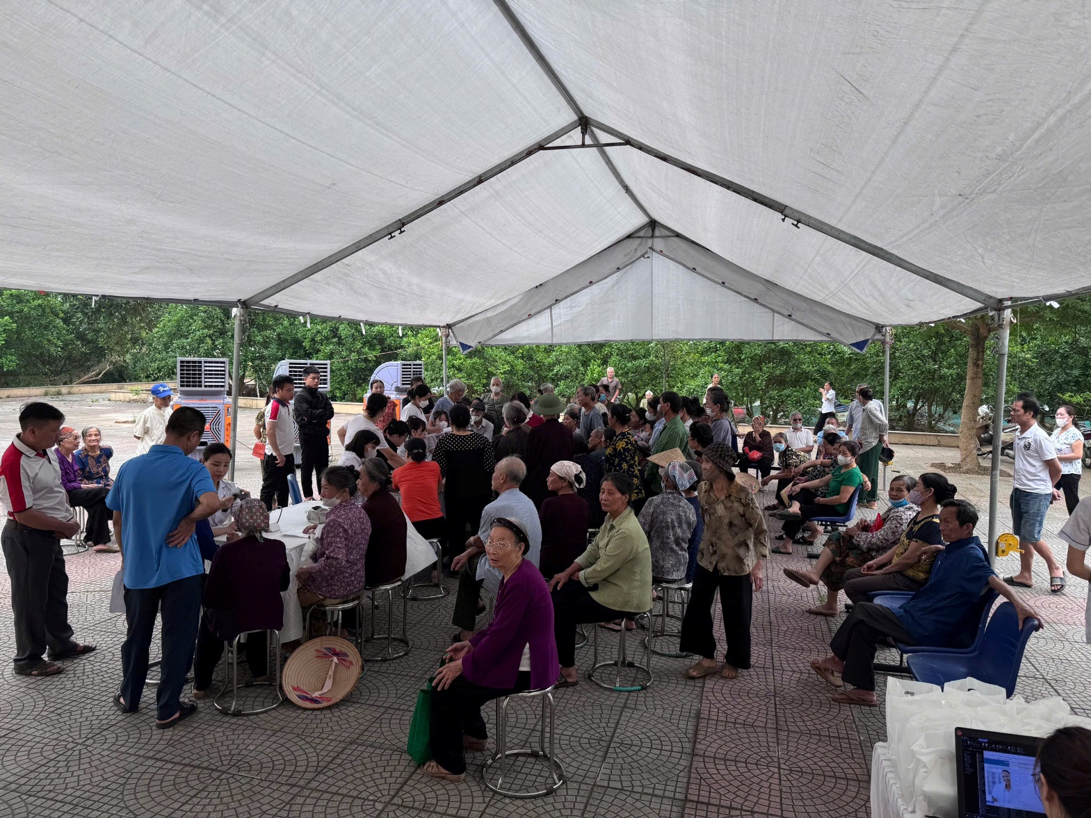 A group of people sitting under a tent  AI-generated content may be incorrect.