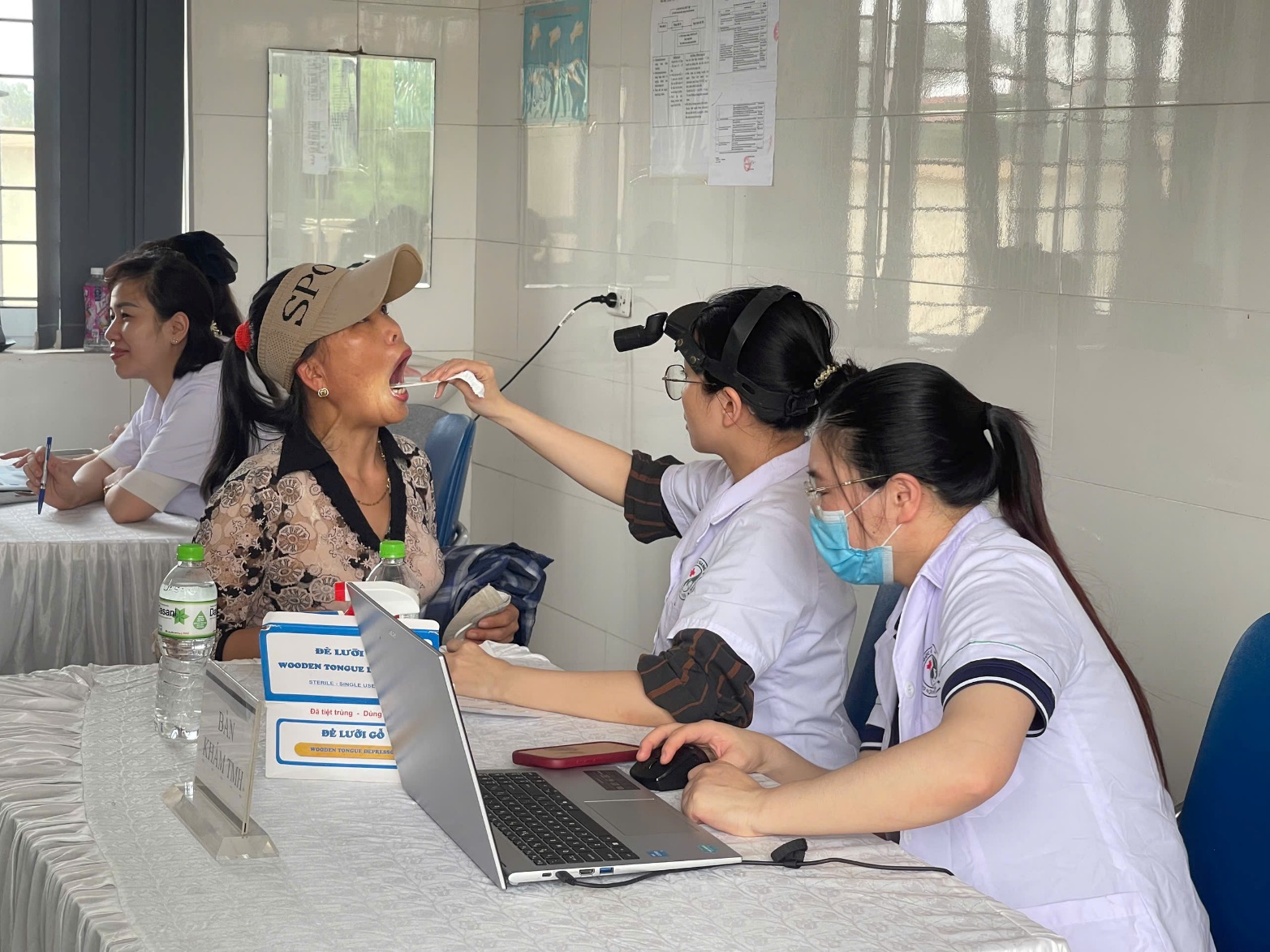 A group of people sitting at a table with a computer  AI-generated content may be incorrect.