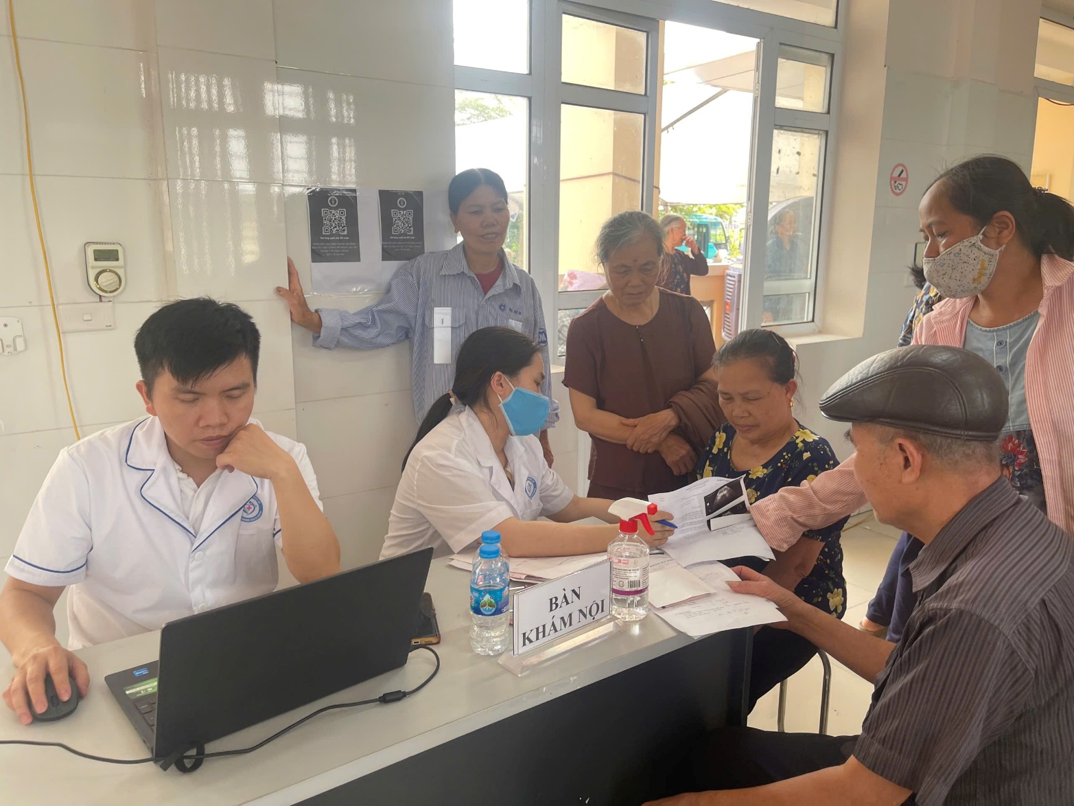 A group of people standing around a desk  AI-generated content may be incorrect.