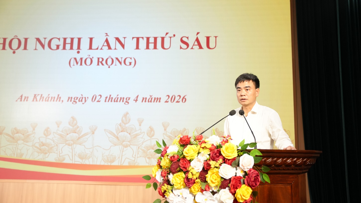 A person standing at a podium with a microphone and flowers  AI-generated content may be incorrect.