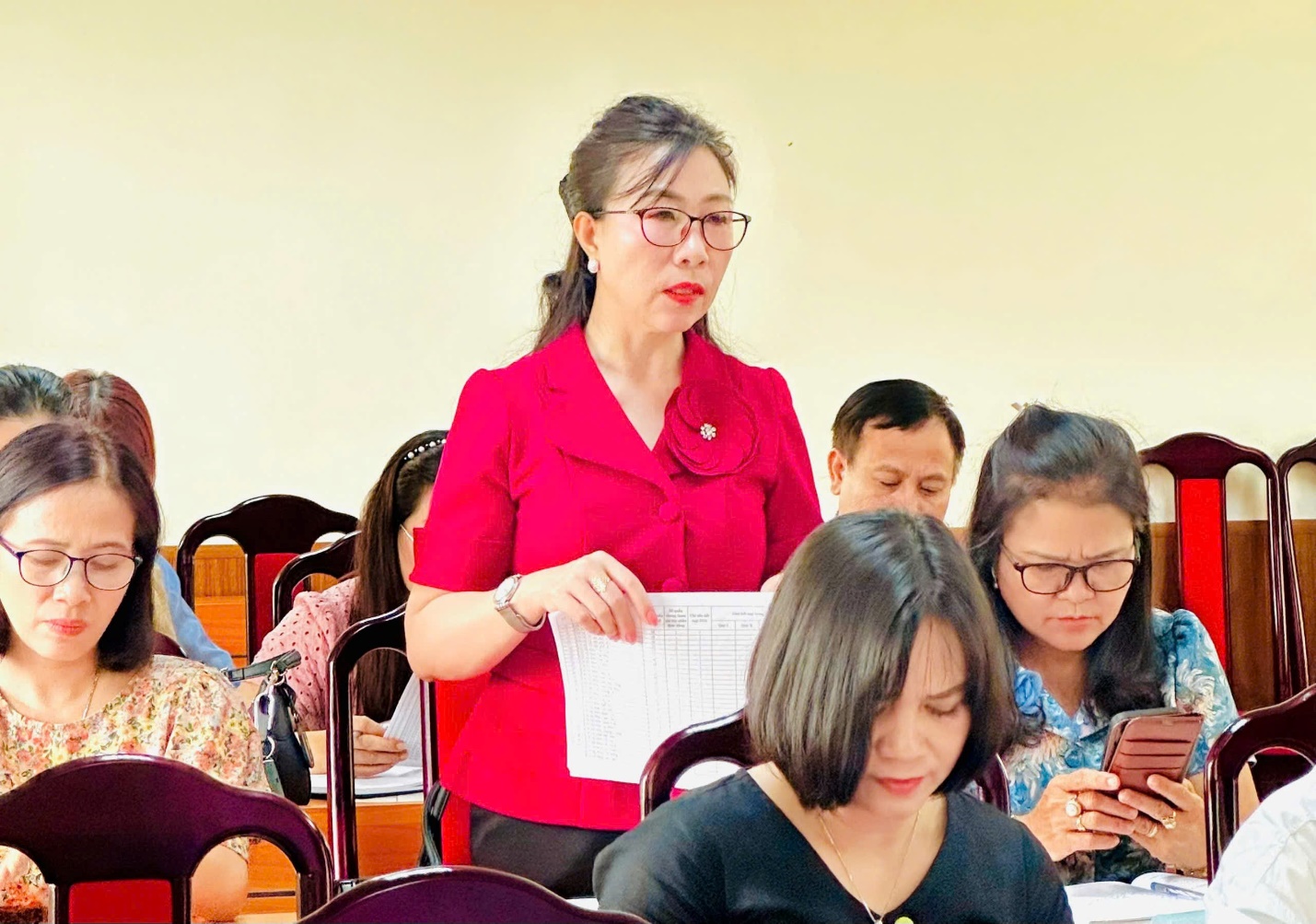 A person standing in front of a group of people  AI-generated content may be incorrect.