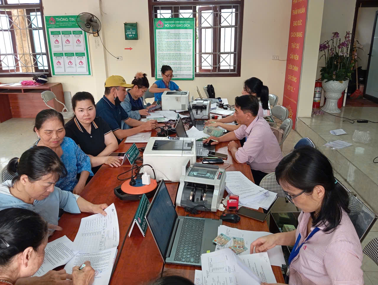 A group of people sitting at a table with papers  AI-generated content may be incorrect.