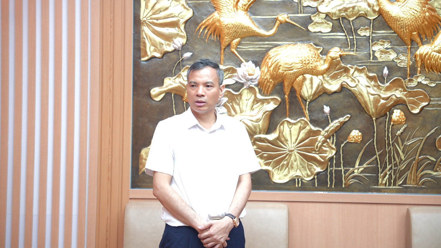 A person standing in front of a wall with gold art  AI-generated content may be incorrect.