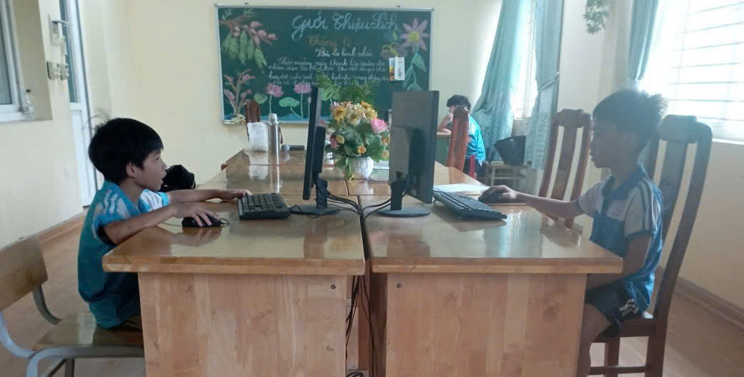 A group of people sitting at a desk with computers  AI-generated content may be incorrect.