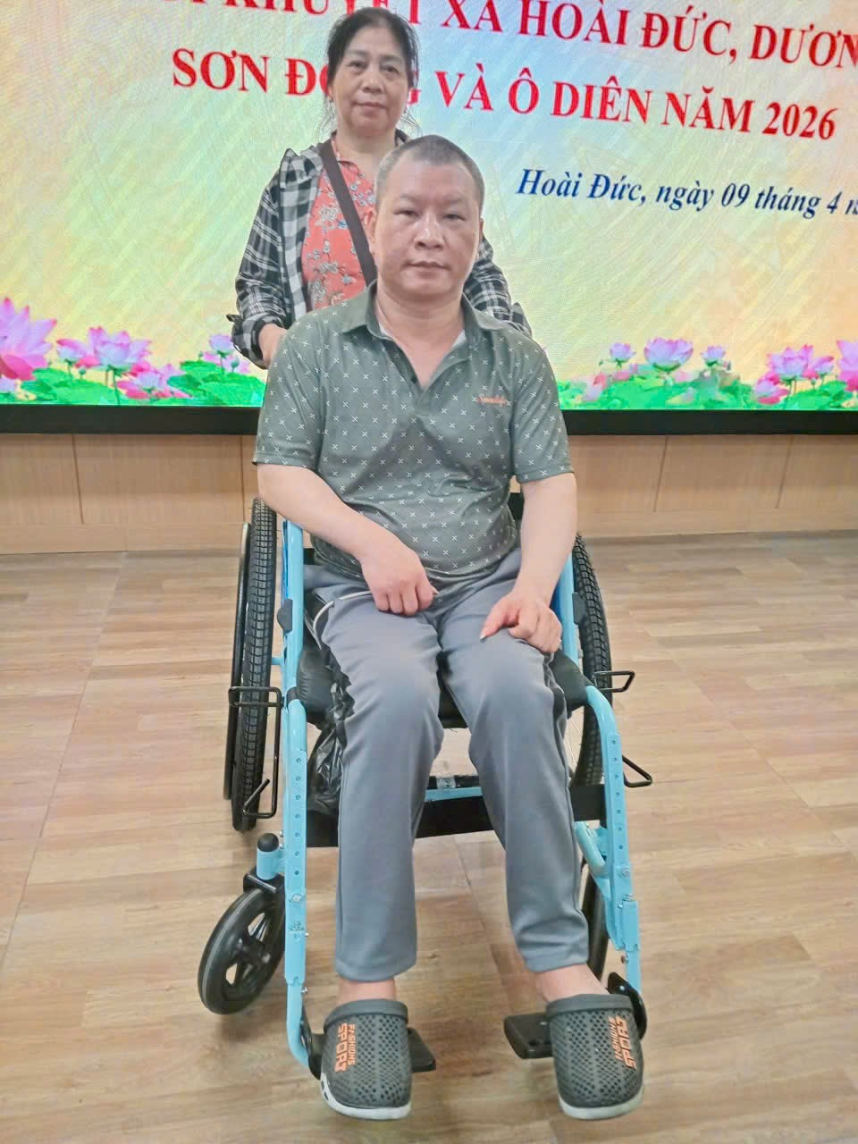 A person in a wheelchair with a person behind him  Description automatically generated