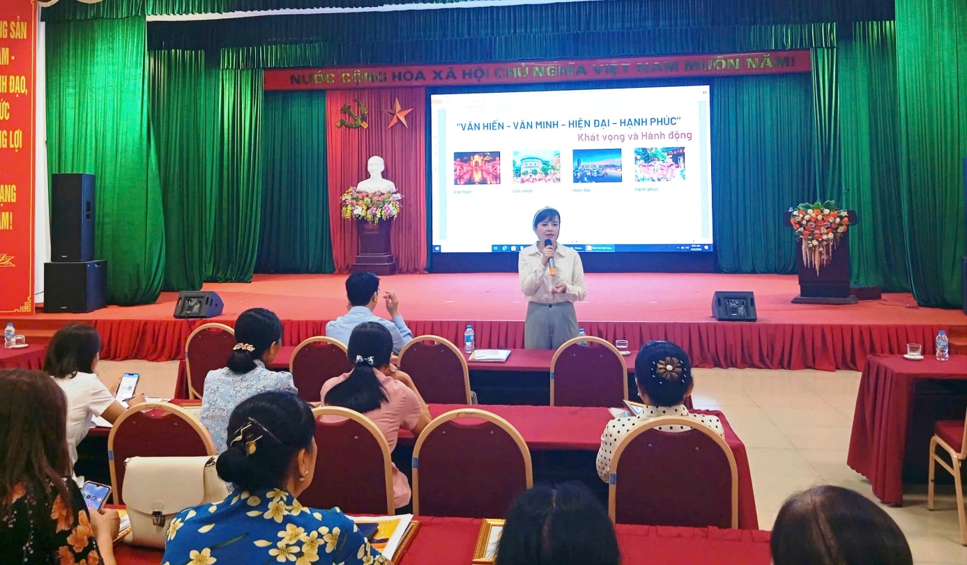 A person standing in front of a stage with a projection screen  AI-generated content may be incorrect.