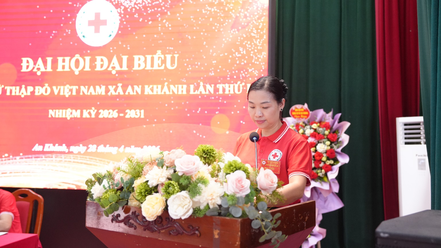 A person standing at a podium with a microphone  AI-generated content may be incorrect.