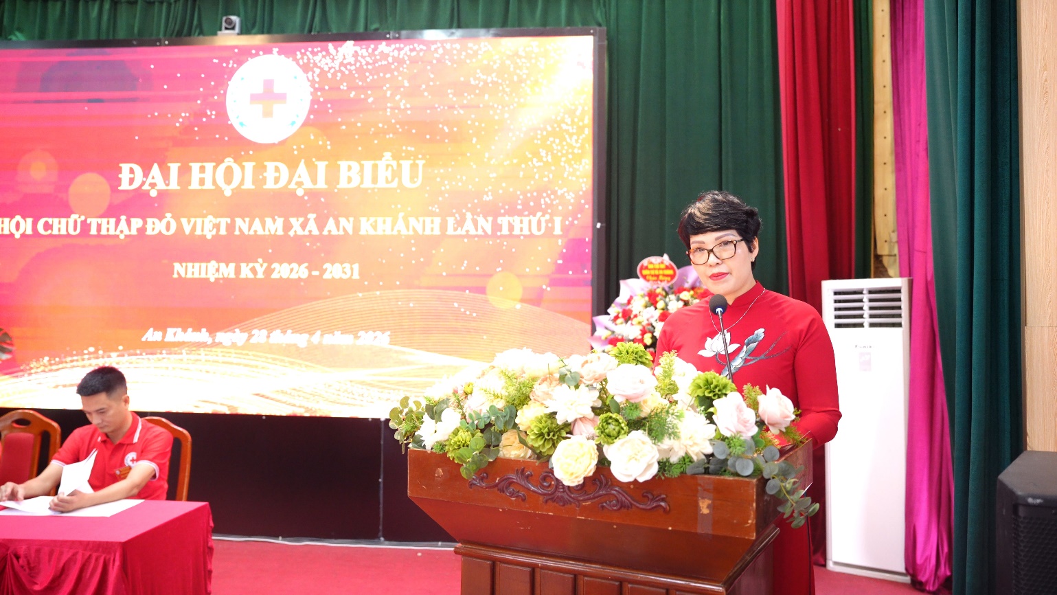 A person standing at a podium with flowers  AI-generated content may be incorrect.