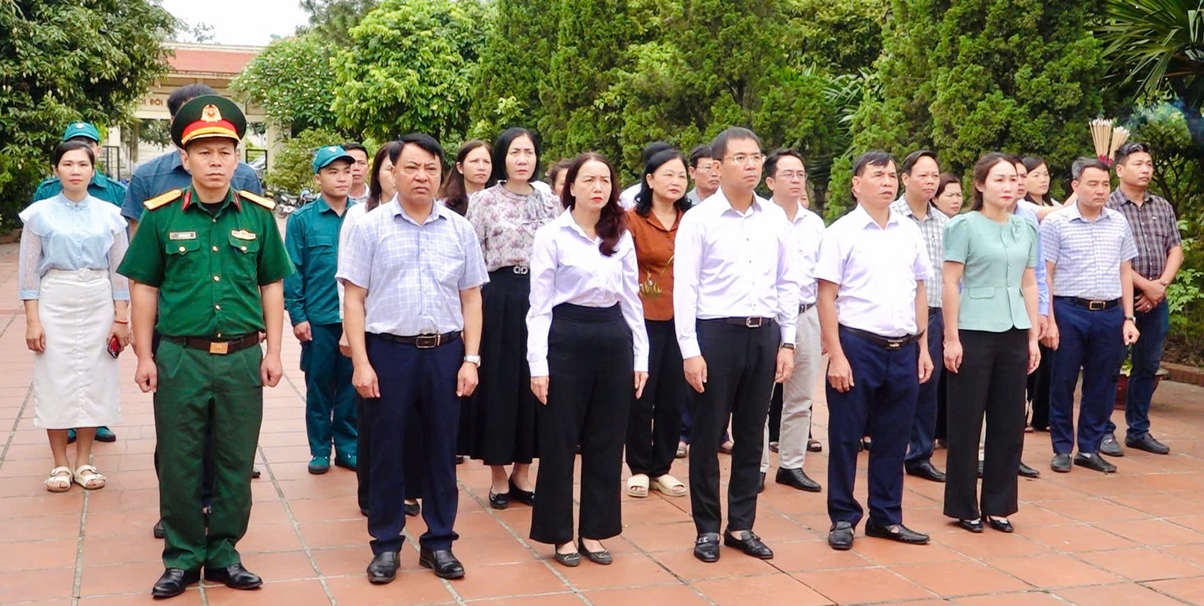 A group of people standing on a brick surface  Description automatically generated