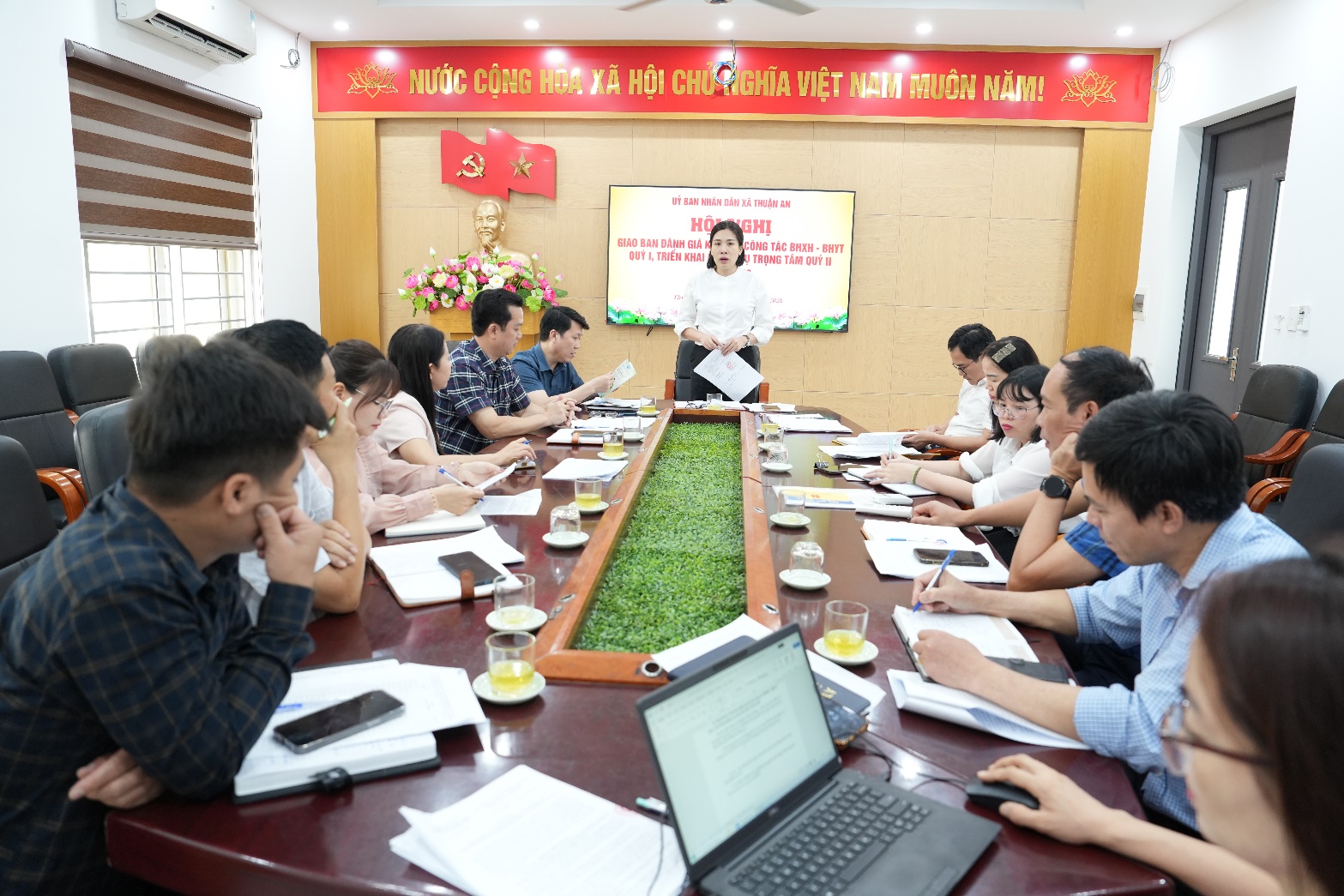 A person standing in front of a group of people sitting around a table  AI-generated content may be incorrect.