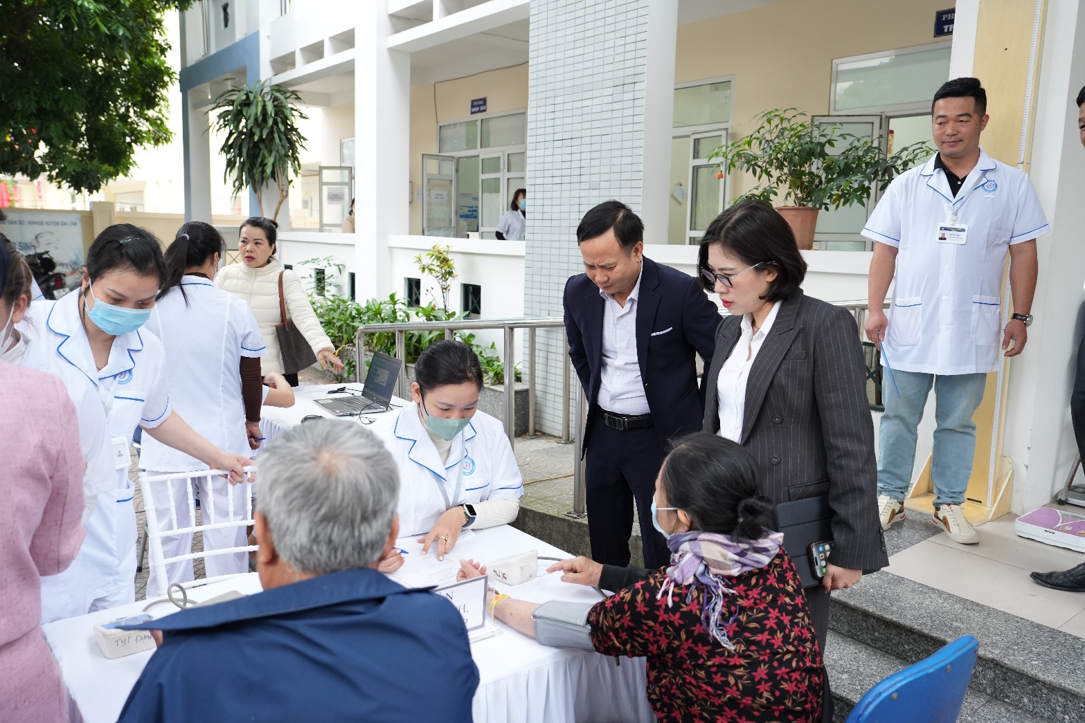 A group of people standing around a table  AI-generated content may be incorrect.