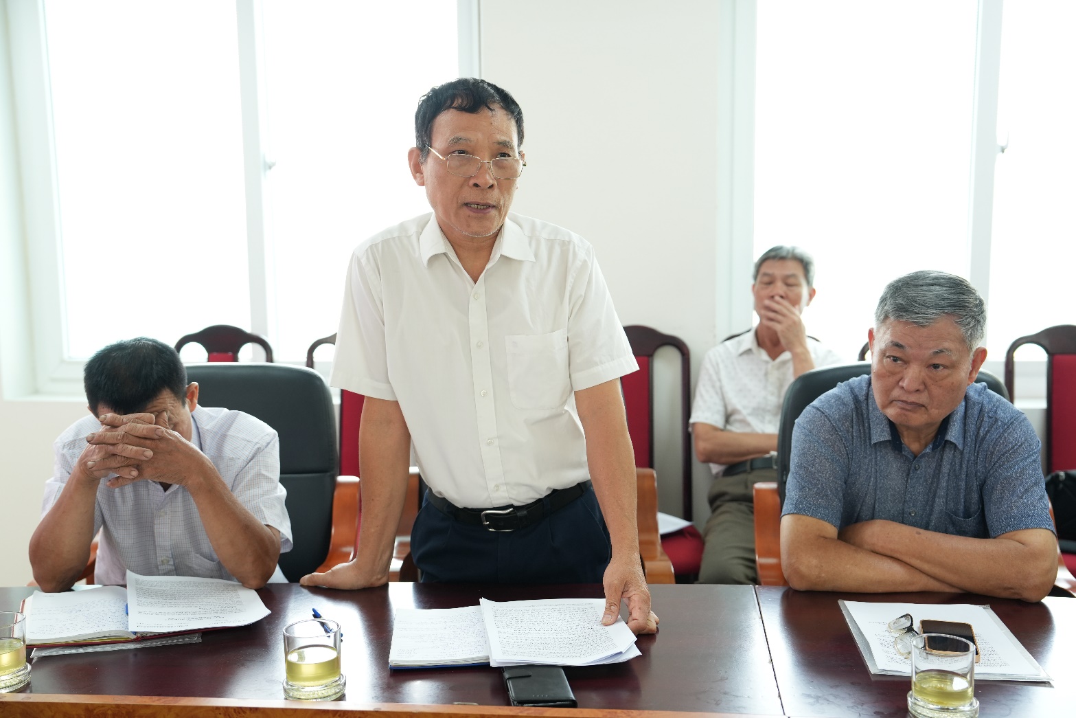 A group of men sitting at a table  AI-generated content may be incorrect.