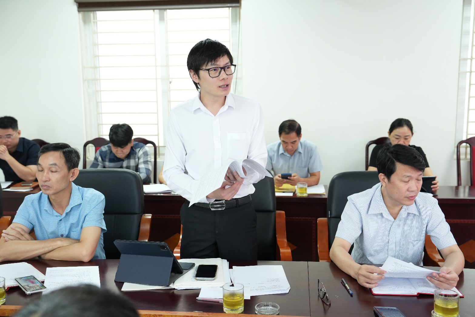 A person standing in front of a group of people  AI-generated content may be incorrect.