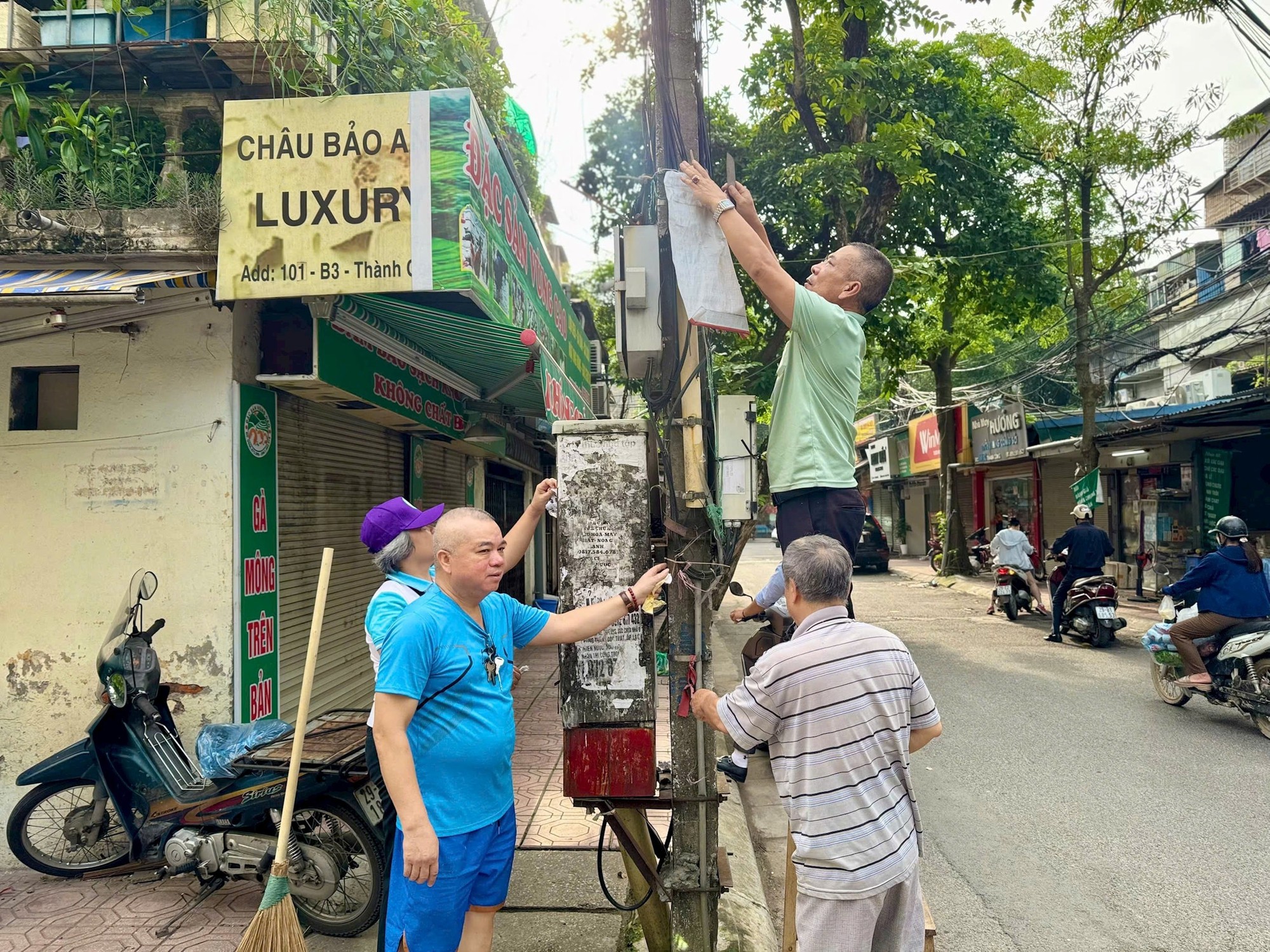 Người dân phường Giảng Võ bóc gỡ quảng cáo, rao vặt. Ảnh: Duy Khánh