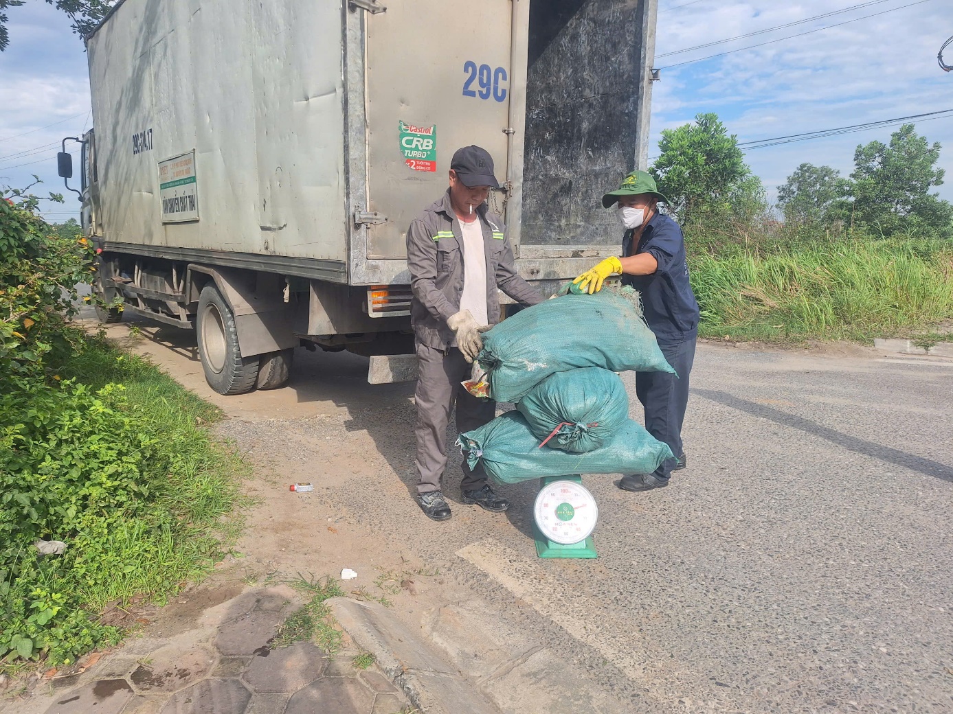 A person and person loading garbage bags  AI-generated content may be incorrect.