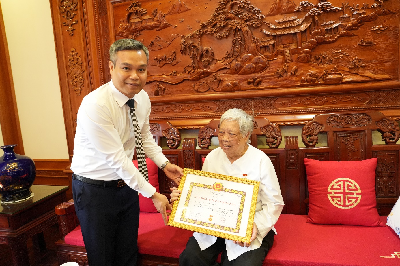 Đồng chí Phó Bí thư Thường trực Đảng ủy xã trao Huy hiệu Đảng đợt 19/5/2026 tại nhà các đảng viên lão thành - Ảnh 1.