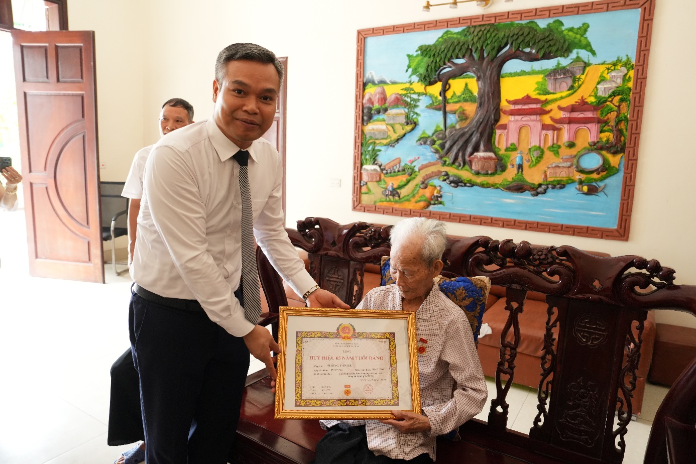 Đồng chí Phó Bí thư Thường trực Đảng ủy xã trao Huy hiệu Đảng đợt 19/5/2026 tại nhà các đảng viên lão thành - Ảnh 3.