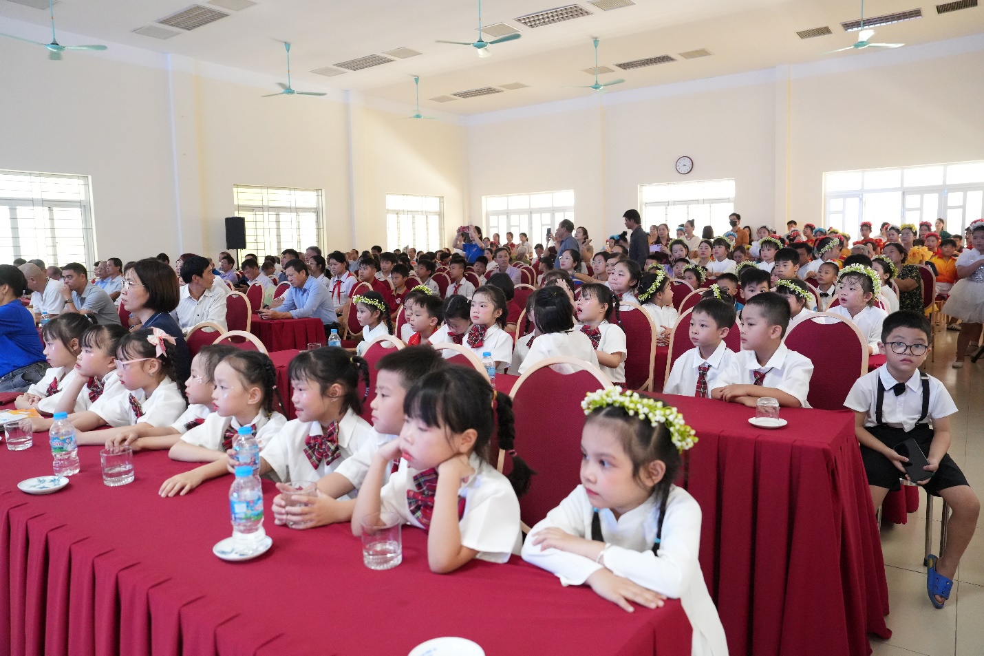 A group of children sitting at tables  AI-generated content may be incorrect.