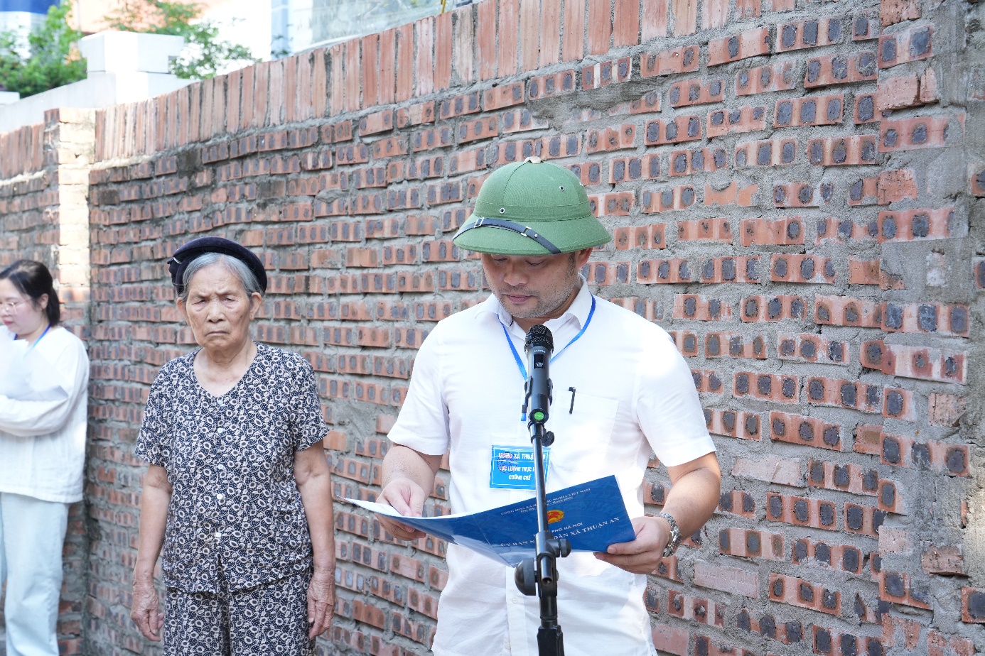 A person in a green hat reading a book in front of a brick wall  AI-generated content may be incorrect.