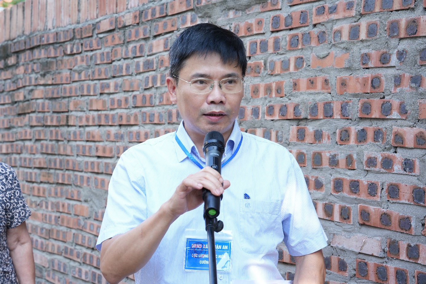 A person standing in front of a brick wall holding a microphone  AI-generated content may be incorrect.