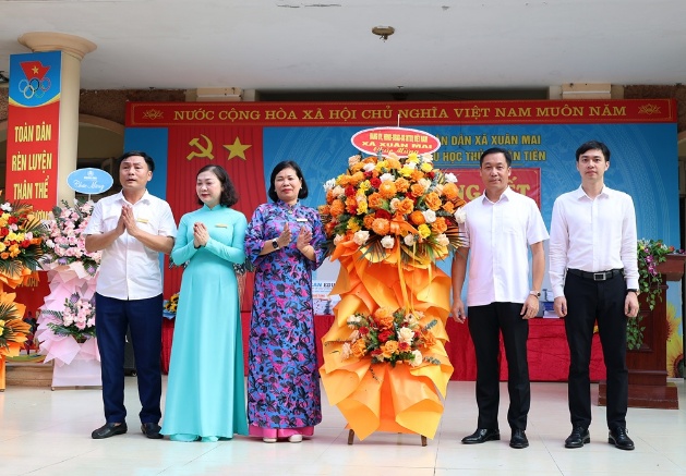 Đồng chí Chủ tịch UBND xã Nguyễn Anh Đức tặng hoa chúc mừng thầy và trò trường Tiểu học Thủy Xuân Tiên trong lễ tổng kết năm học 2025 - 2026- Ảnh 1.