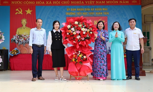 Đồng chí Chủ tịch UBND xã Nguyễn Anh Đức tặng hoa chúc mừng thầy và trò trường Tiểu học Thủy Xuân Tiên trong lễ tổng kết năm học 2025 - 2026- Ảnh 2.