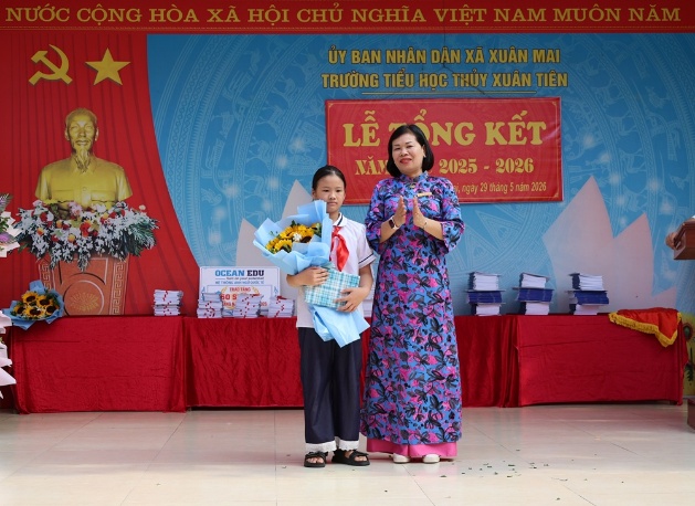 Đồng chí Chủ tịch UBND xã Nguyễn Anh Đức tặng hoa chúc mừng thầy và trò trường Tiểu học Thủy Xuân Tiên trong lễ tổng kết năm học 2025 - 2026- Ảnh 6.