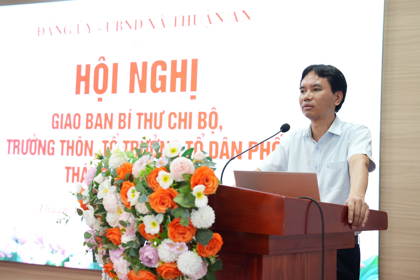 A person standing at a podium with a microphone  AI-generated content may be incorrect.