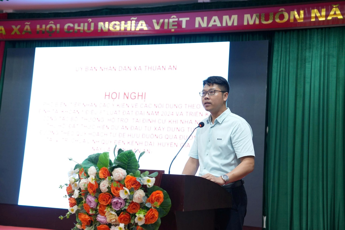 A person standing at a podium with a microphone  AI-generated content may be incorrect.