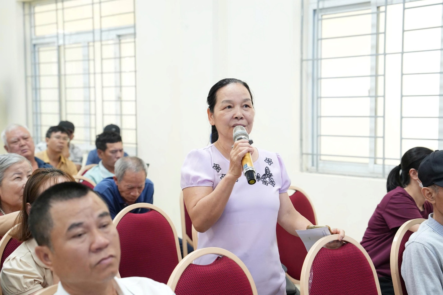 A person speaking into a microphone  AI-generated content may be incorrect.