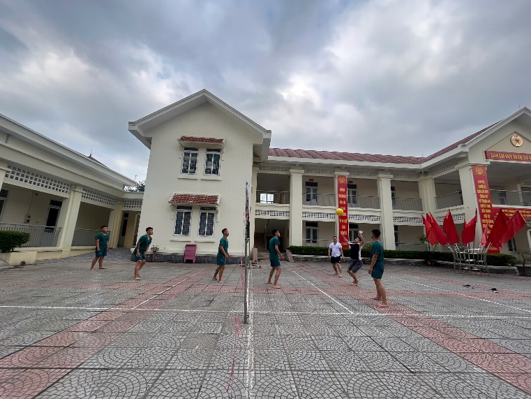 A group of people playing volleyball in a courtyard  AI-generated content may be incorrect.