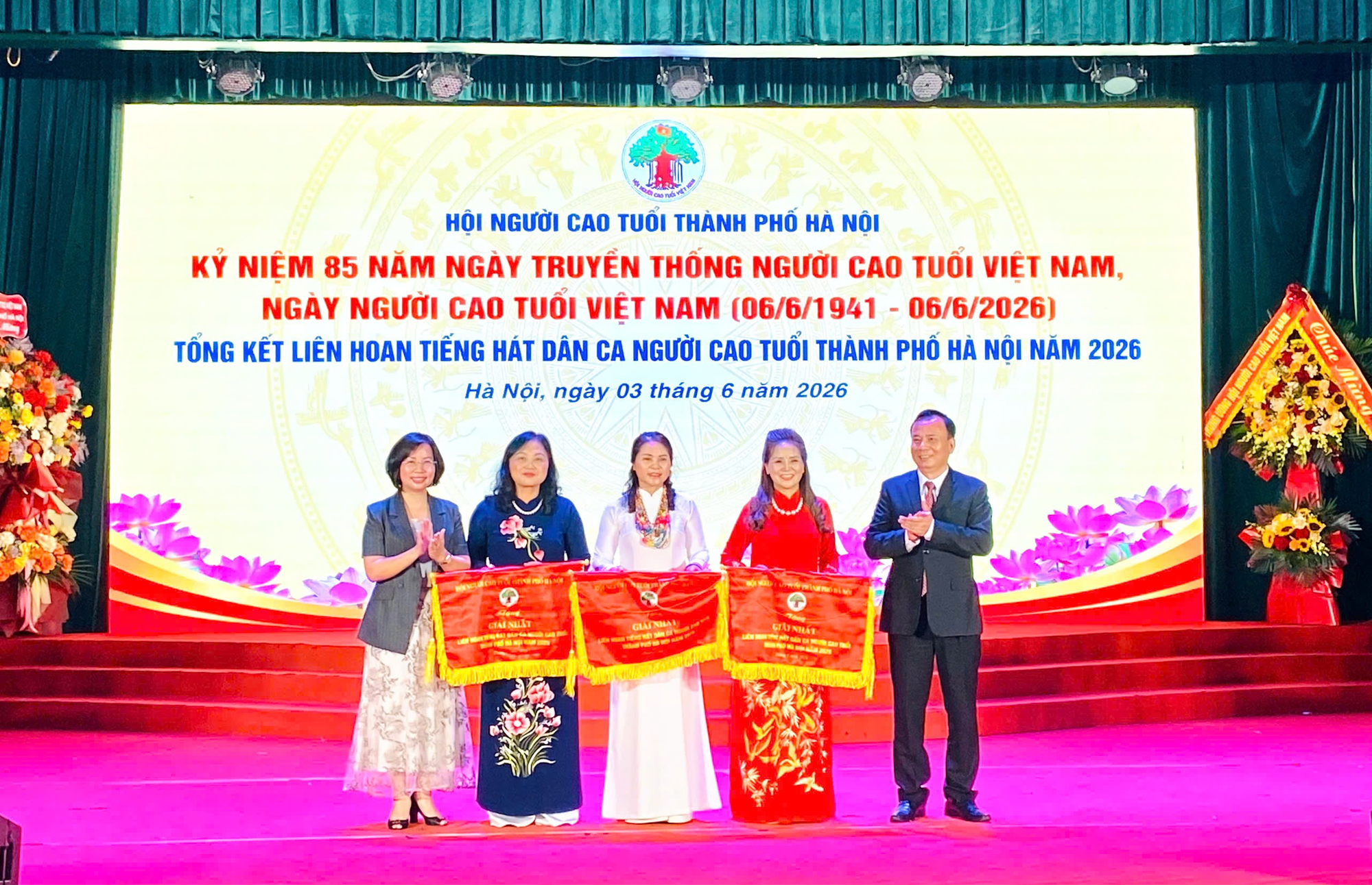 A group of people standing on a stage  Description automatically generated