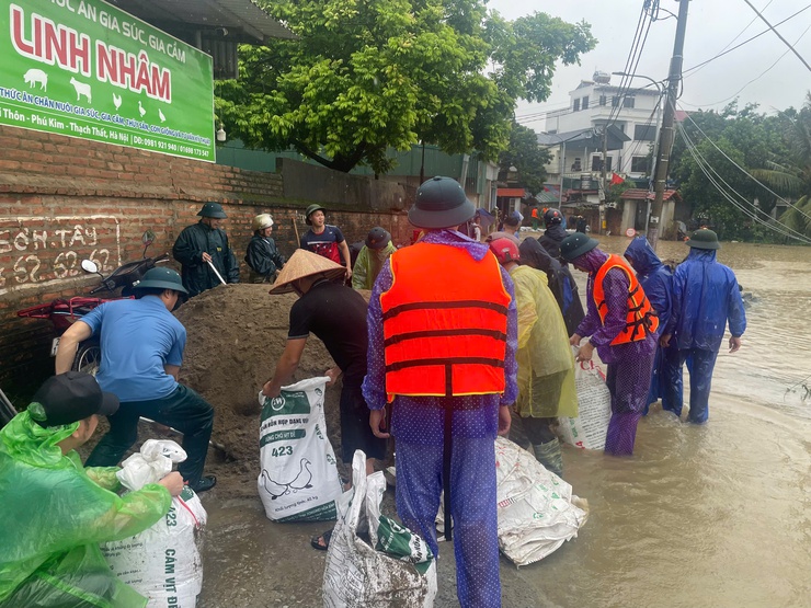 Lực lượng Dân quân thường trực xã tham gia hỗ trợ nhân dân ứng phó với mưa lũ, khắc phục hậu quả sau bão số 5.- Ảnh 1.