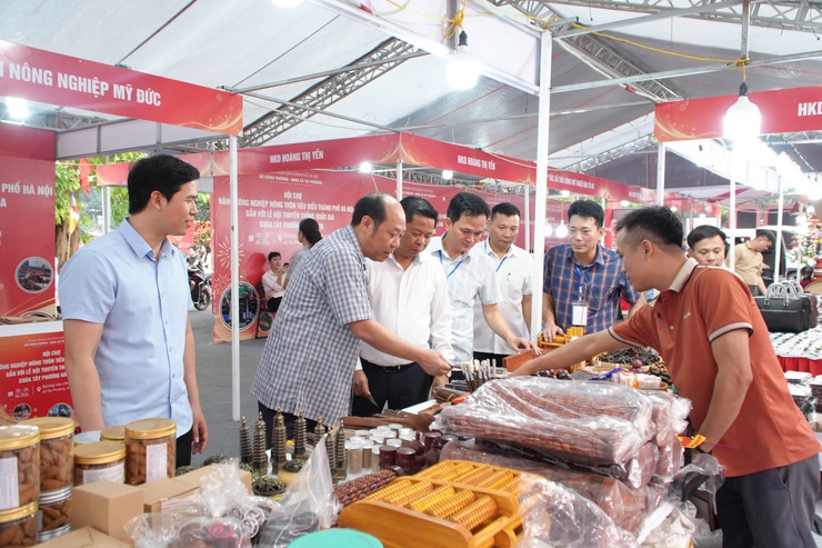 Đoàn công tác lãnh đạo xã trực tiếp khảo sát, kiểm tra thực tế tại khu vực các gian hàng trưng bày sản phẩm OCOP và làng nghề truyền thống.- Ảnh 1.