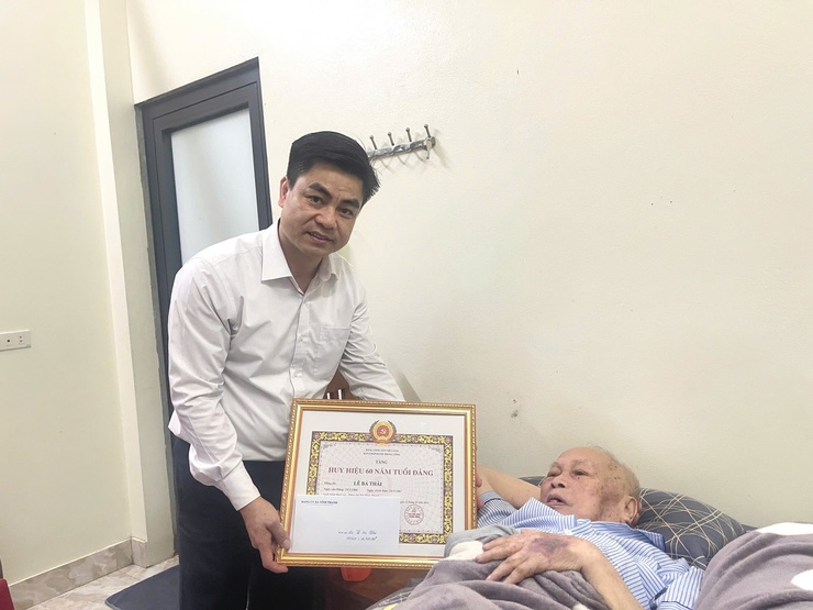 Đồng chí Nguyễn Tuấn Hà – Phó Bí thư Thường trực Đảng ủy xã Vĩnh Thanh trao tặng Huy hiệu 60 năm tuổi Đảng tại nhà riêng cho đồng chí Lê Bá Thái.- Ảnh 6.