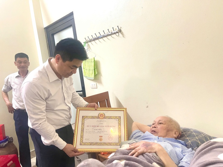 Đồng chí Nguyễn Tuấn Hà – Phó Bí thư Thường trực Đảng ủy xã Vĩnh Thanh trao tặng Huy hiệu 60 năm tuổi Đảng tại nhà riêng cho đồng chí Lê Bá Thái.- Ảnh 2.