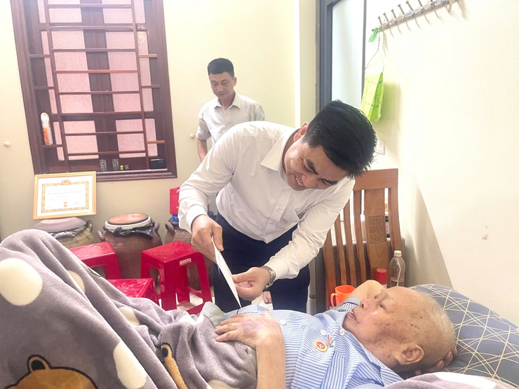 Đồng chí Nguyễn Tuấn Hà – Phó Bí thư Thường trực Đảng ủy xã Vĩnh Thanh trao tặng Huy hiệu 60 năm tuổi Đảng tại nhà riêng cho đồng chí Lê Bá Thái.- Ảnh 4.