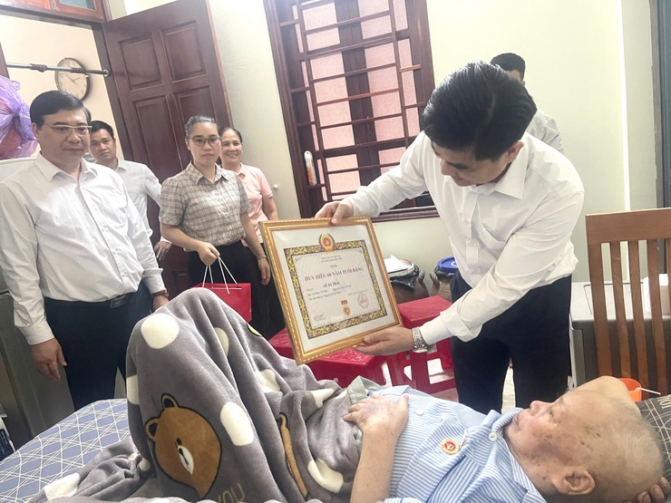 Đồng chí Nguyễn Tuấn Hà – Phó Bí thư Thường trực Đảng ủy xã Vĩnh Thanh trao tặng Huy hiệu 60 năm tuổi Đảng tại nhà riêng cho đồng chí Lê Bá Thái.- Ảnh 3.