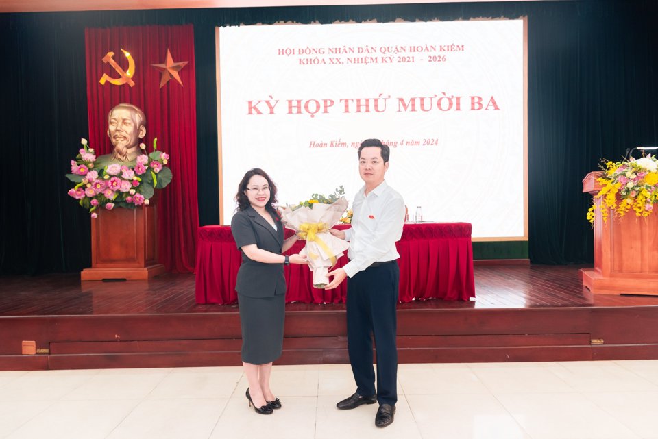 Bí thư Quận ủy, Chủ tịch HĐND quận Hoàn Kiếm Vũ Đăng Định tặng hoa chúc mừng bà Trịnh Ngọc Trâm - Trưởng phòng Giáo dục và Đào tạo quận Hoàn Kiếm.