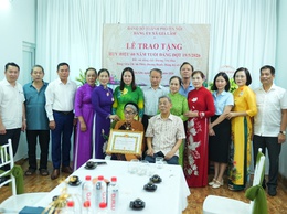 Đồng chí Phó Bí thư Thường trực Đảng ủy trao tặng Huy hiệu 60 năm tuổi Đảng tại nhà cho đồng chí Dương Thị Hòa
