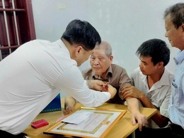 Đồng chí Phó Bí thư Thường trực Đảng ủy xã Dương Chí Thanh trao Huy hiệu 60 năm tuổi Đảng cho đảng viên sức khỏe yếu đi lại khó khăn