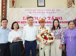 Đồng chí Lê Ngọc Anh, Thành ủy viên, Bí thư Đảng ủy xã Gia Lâm trao Huy hiệu 80 năm tuổi Đảng cho đảng viên Nguyễn Huy Thuân